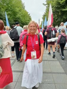 Na zdjęciu widzimy pielgrzymującą kobietę z Caritas Sosnowiec wśród innych pielgrzymów