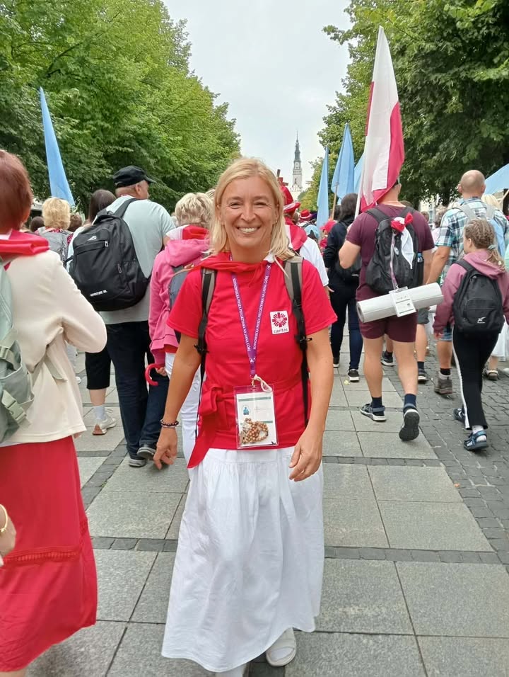 Na zdjęciu widzimy pielgrzymującą kobietę z Caritas Sosnowiec wśród innych pielgrzymów