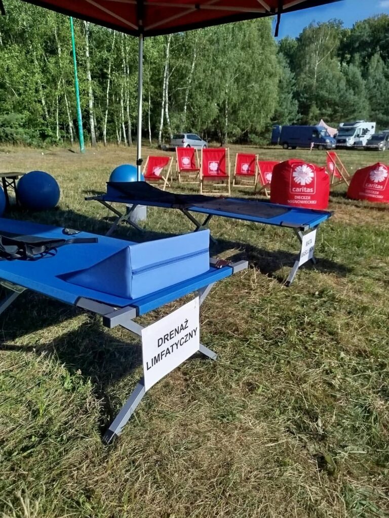 na zdjęciu widzimy łóżko do drenażu limfatycznego ustawione na trawie w plenerze