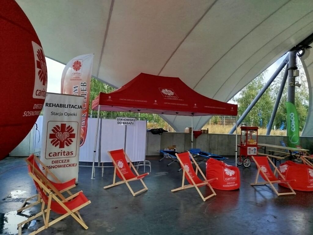 na zdjęciu widzimy leżaki z logiem Caritas oraz baner reklamowy Caritas